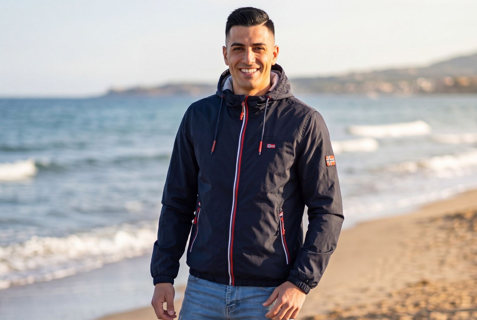 chico sonriendo en la playa con una chaqueta ligera | geographical norway